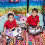 Junior Kindergarten students reading in a cozy reading corner.